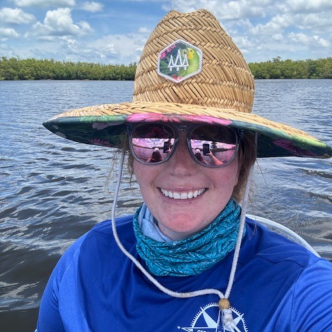 a person wearing a blue hat in front of a body of water