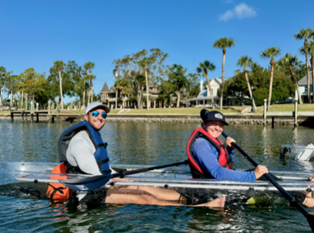 a group of people rowing a boat in a body of water