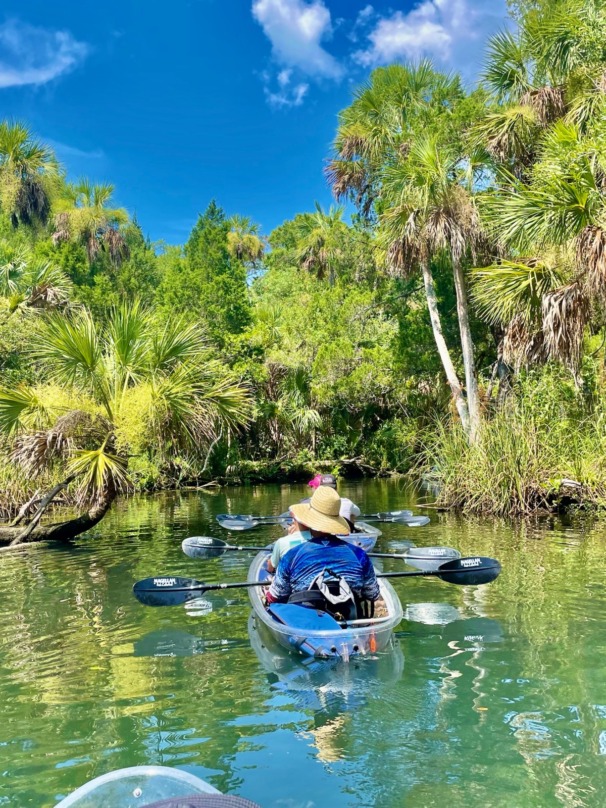 a man riding on the back of a boat next to a lake