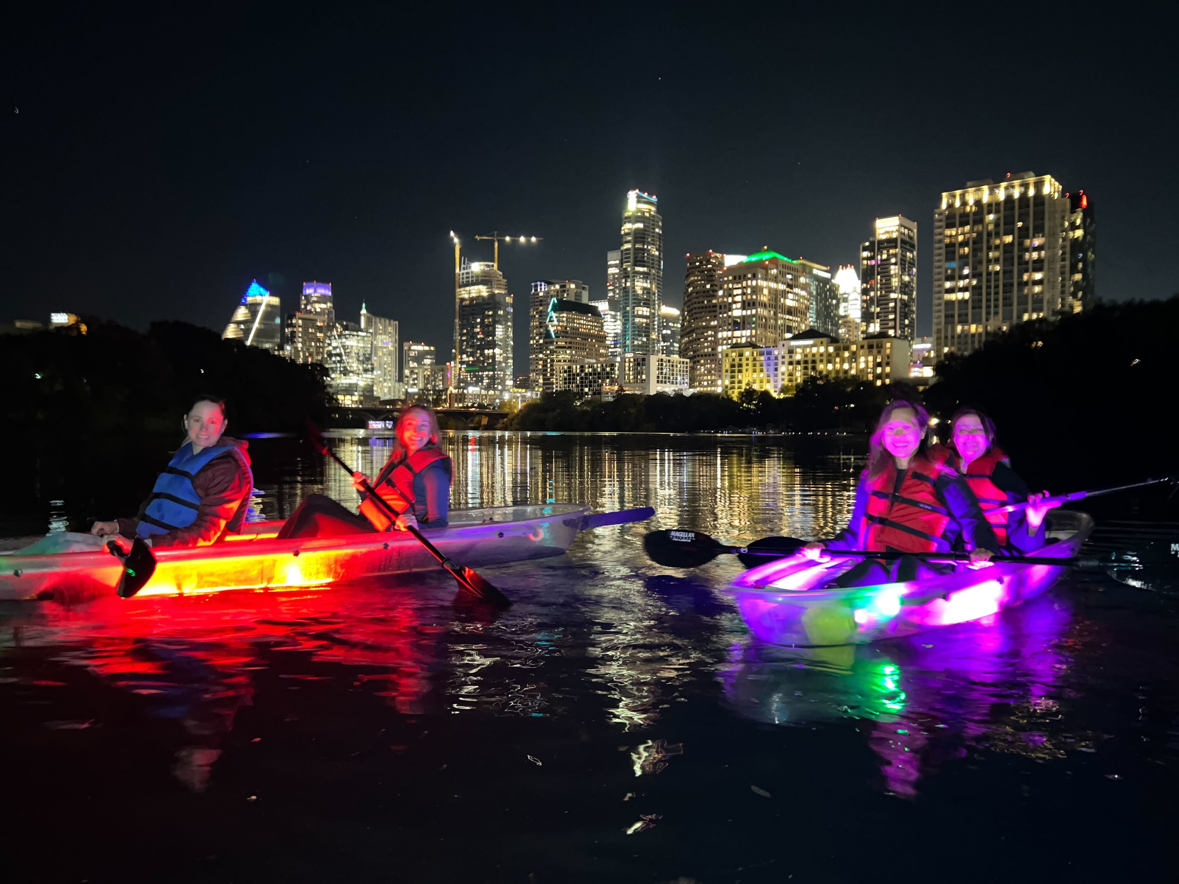 a group of people riding on the back of a boat at night