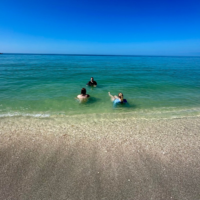 a group of people on a beach near a body of water