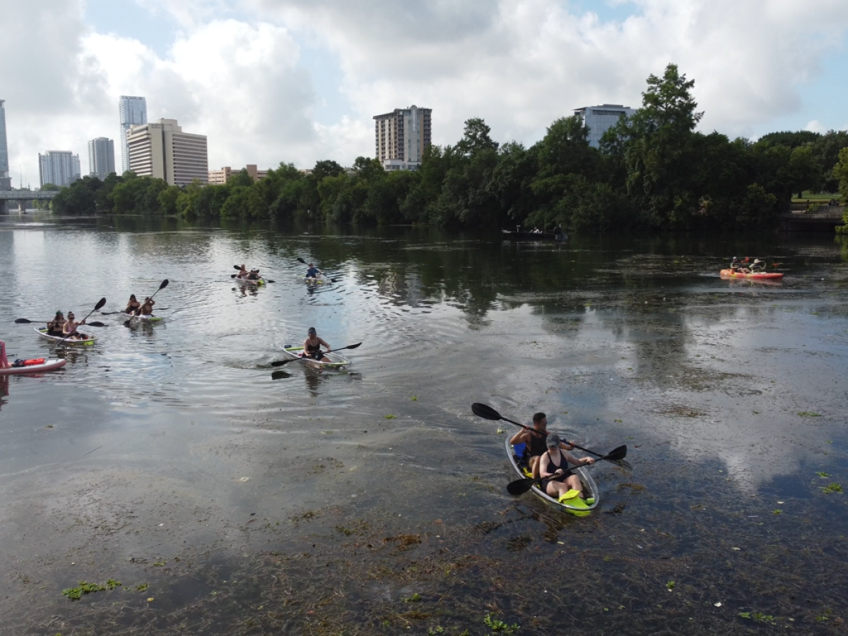 a group of people standing next to a body of water