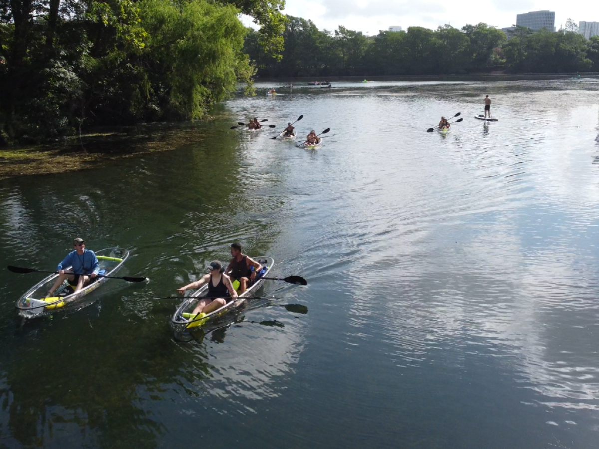 a group of people riding on the back of a boat in the water
