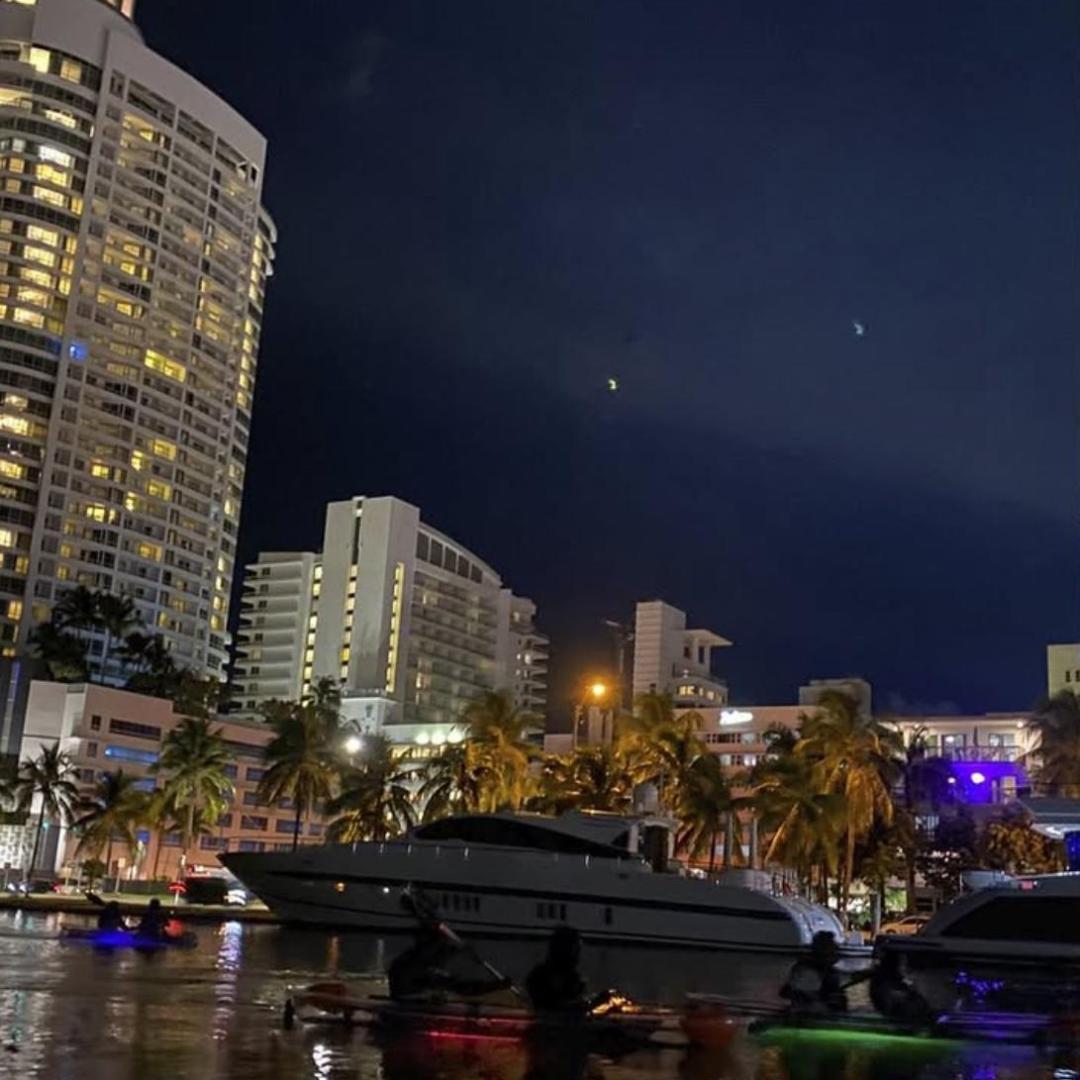 a small boat in a body of water with a city in the background