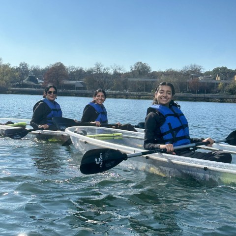 a group of people rowing a boat in the water