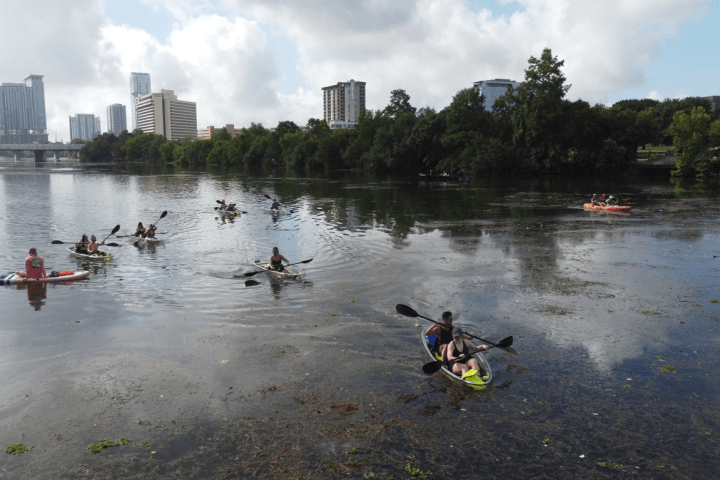 a group of people standing next to a body of water