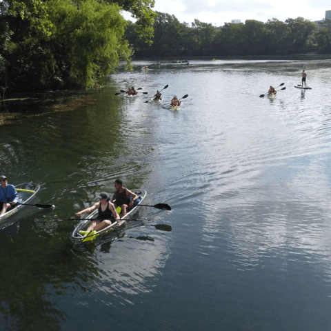 a group of people riding on the back of a boat in the water