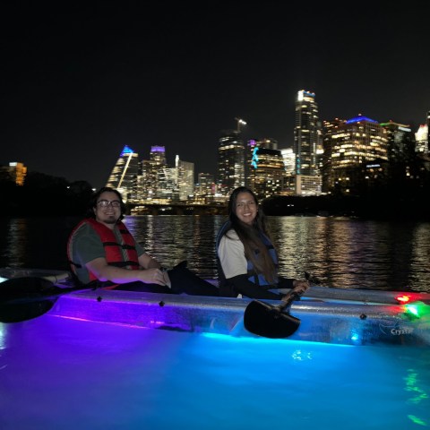 a group of people riding on the back of a boat in the water