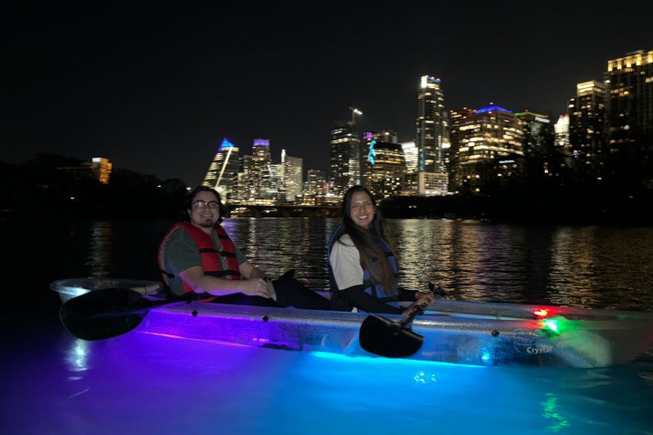 a group of people riding on the back of a boat in the water