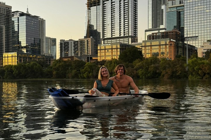a man floating in the water with a city in the background