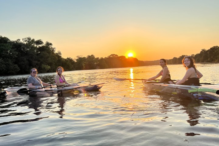 a group of people riding on the back of a boat in the water