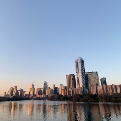 a bridge over a body of water with a city in the background