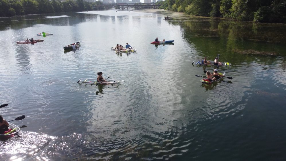 a group of people riding on the back of a boat in the water