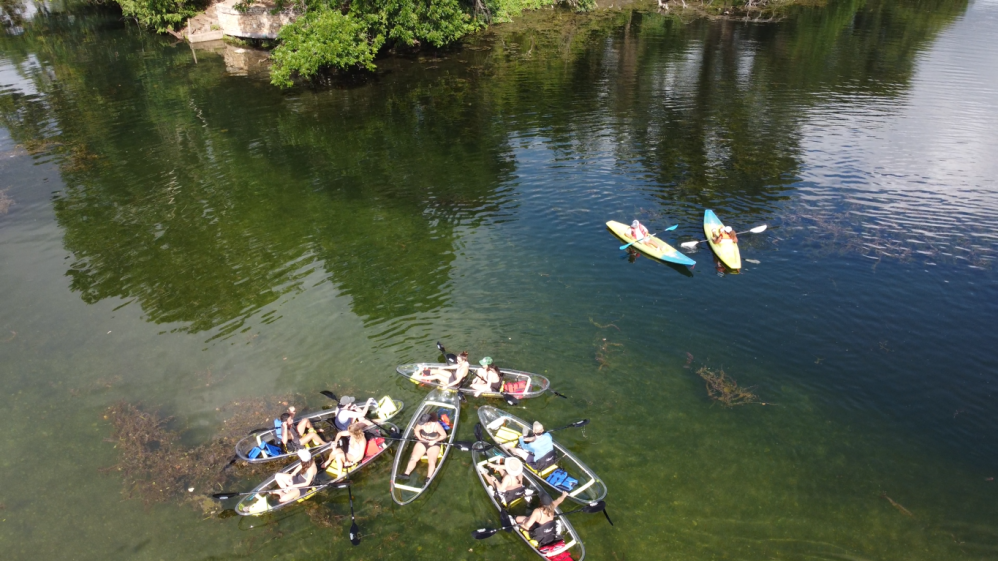 a group of people standing next to a body of water