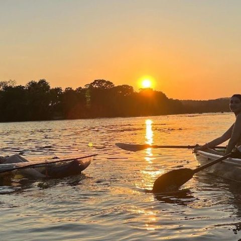 a group of people riding on the back of a boat in the water