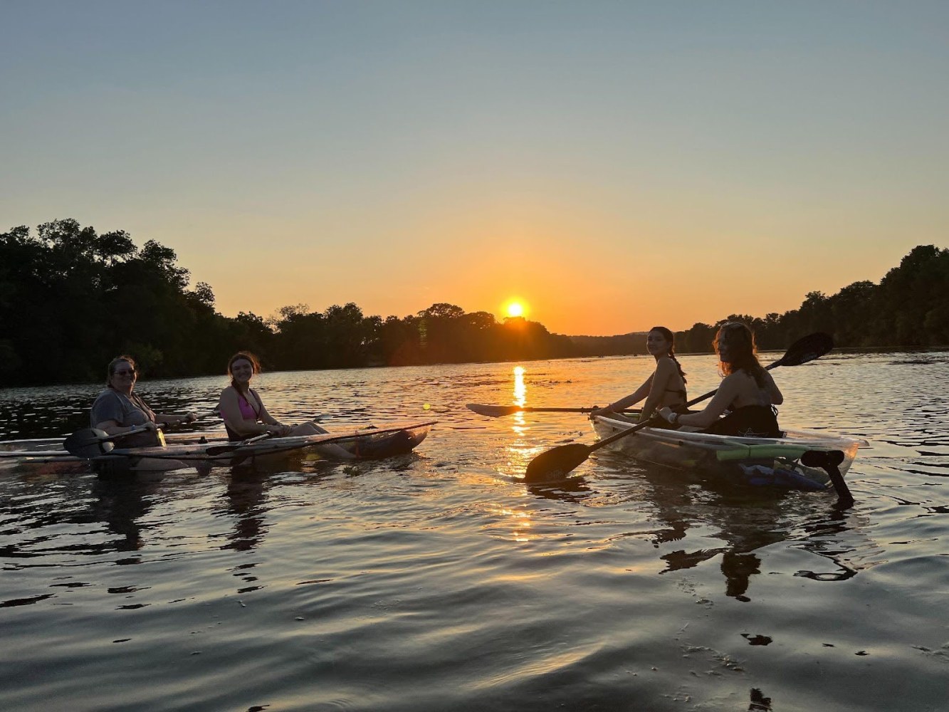 a group of people riding on the back of a boat in the water