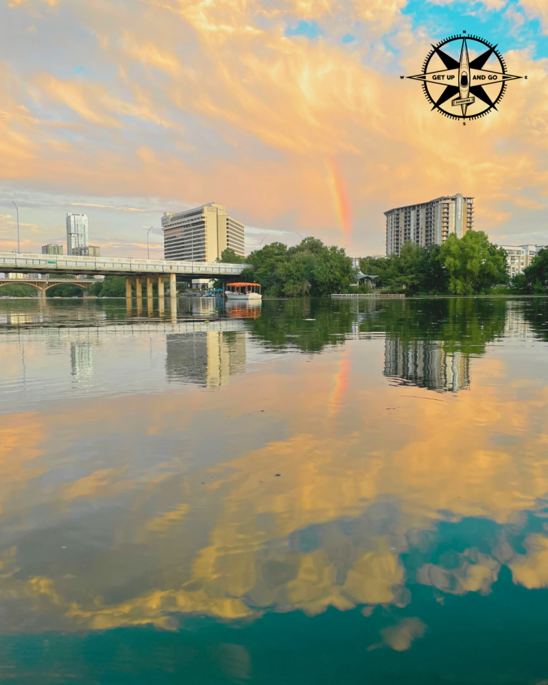 a sunset over a body of water with a city in the background