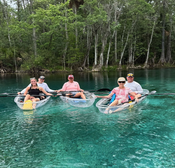 a group of people riding on the back of a boat in the water