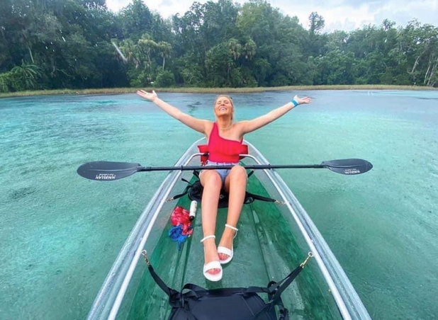 a woman standing in front of a body of water
