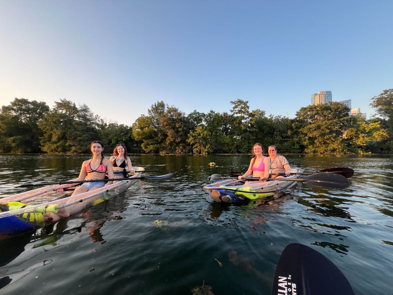 a group of people riding on the back of a boat in the water