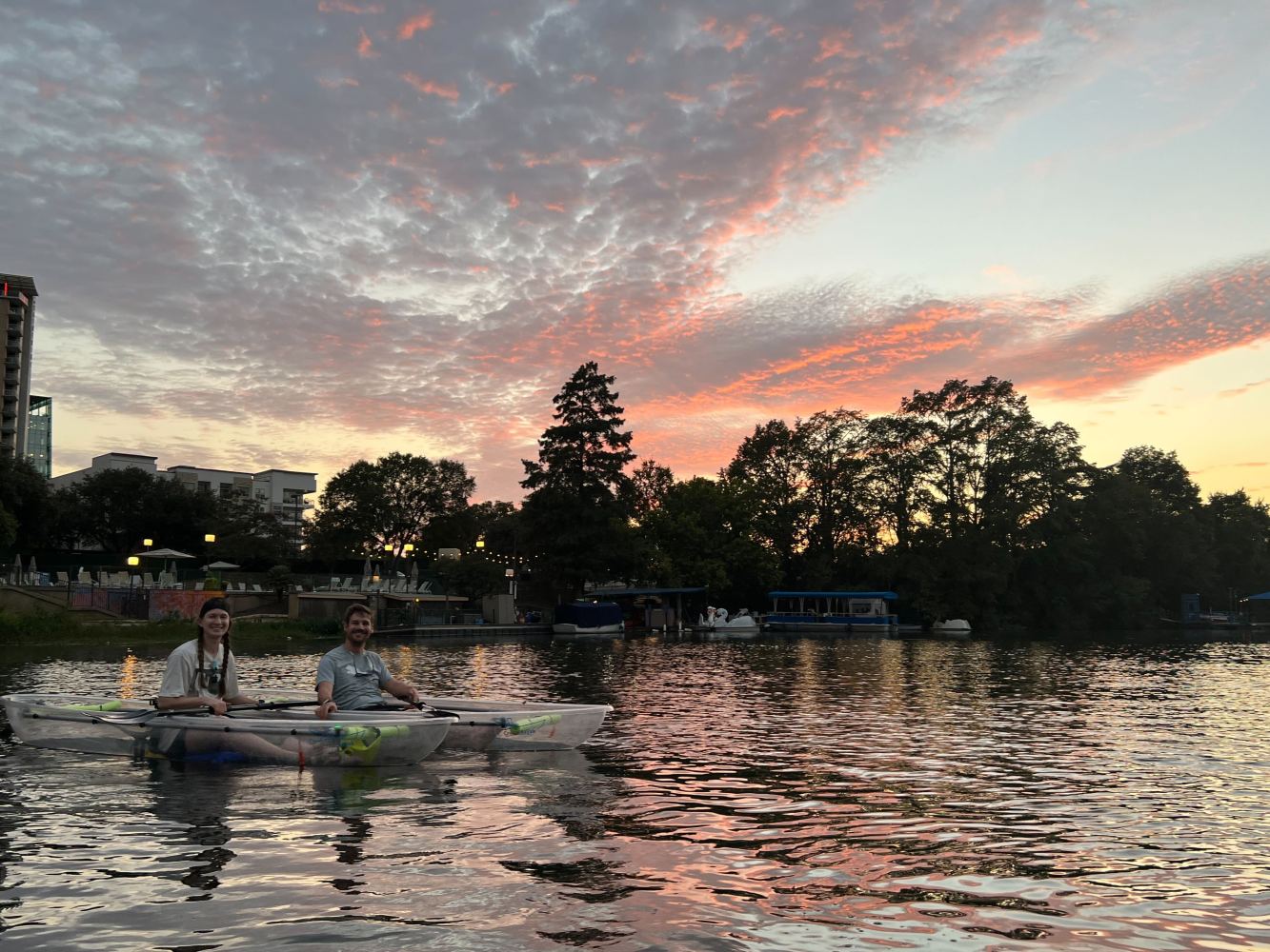 a sunset over a body of water with a city in the background