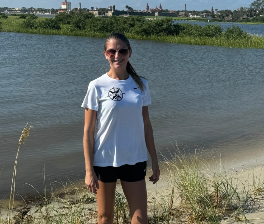 a woman standing in front of a body of water