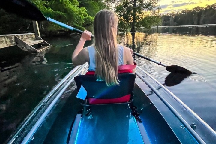 a person sitting on a dock next to a body of water