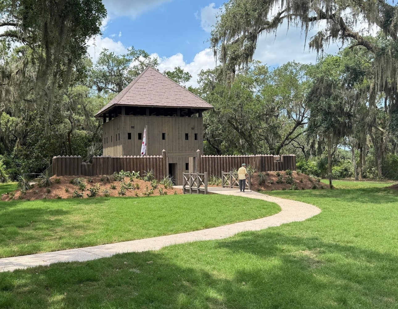 a small house in a grassy area with trees in the background