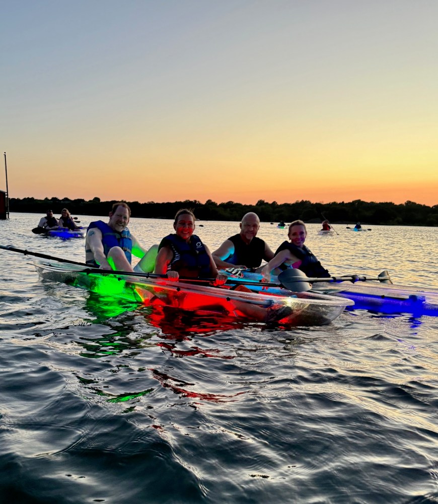 a group of people riding on the back of a boat in the water