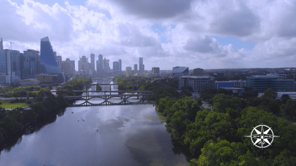 a bridge over a body of water with a city in the background