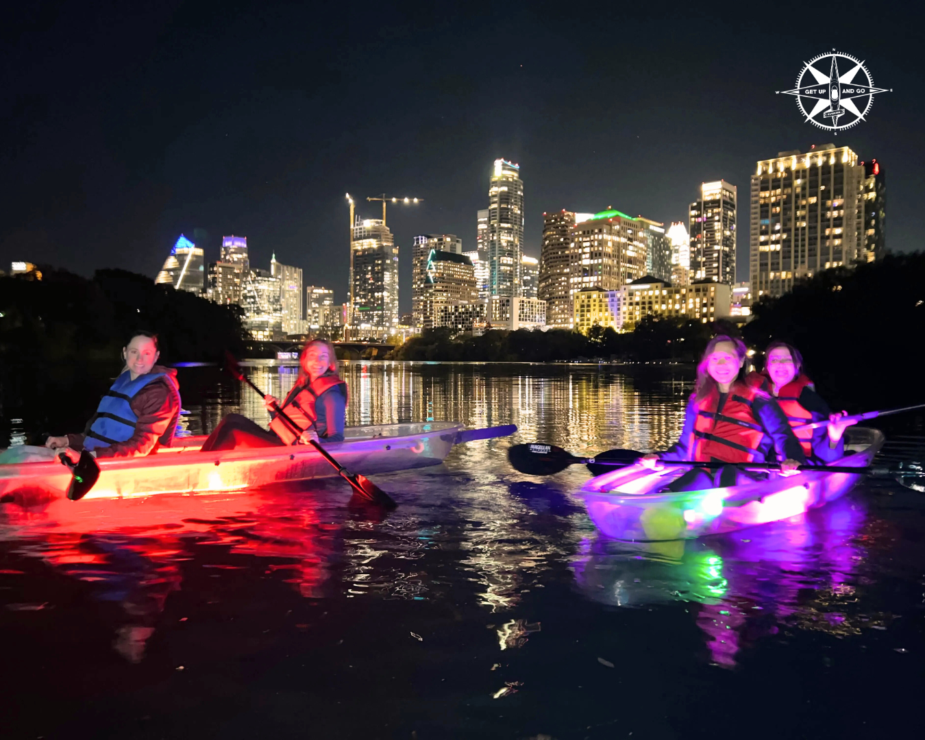 a group of people riding on the back of a boat at night
