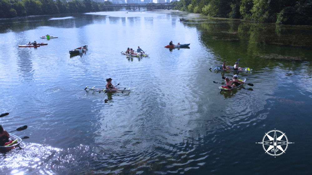 a group of people riding on the back of a boat in the water
