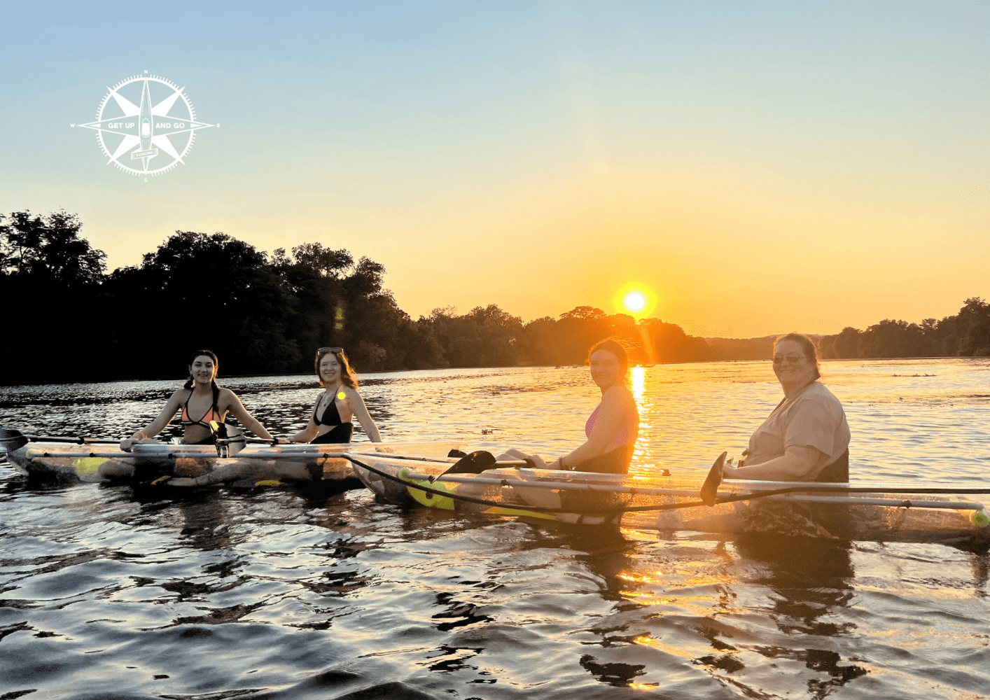 Four people paddle canoes on a river at sunset, with trees and a compass design in the background.