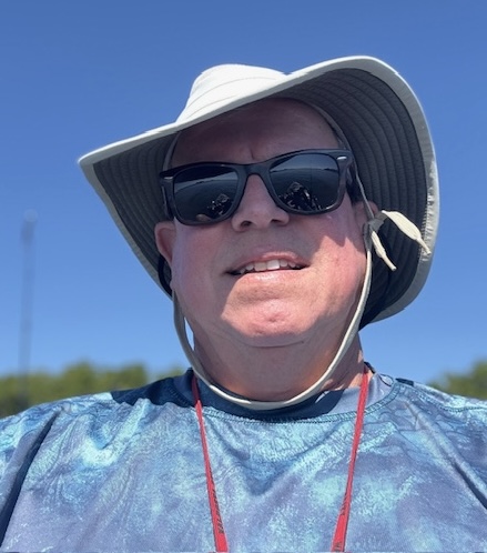 a man standing next to a body of water