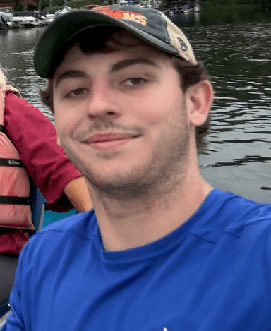 a man standing next to a body of water