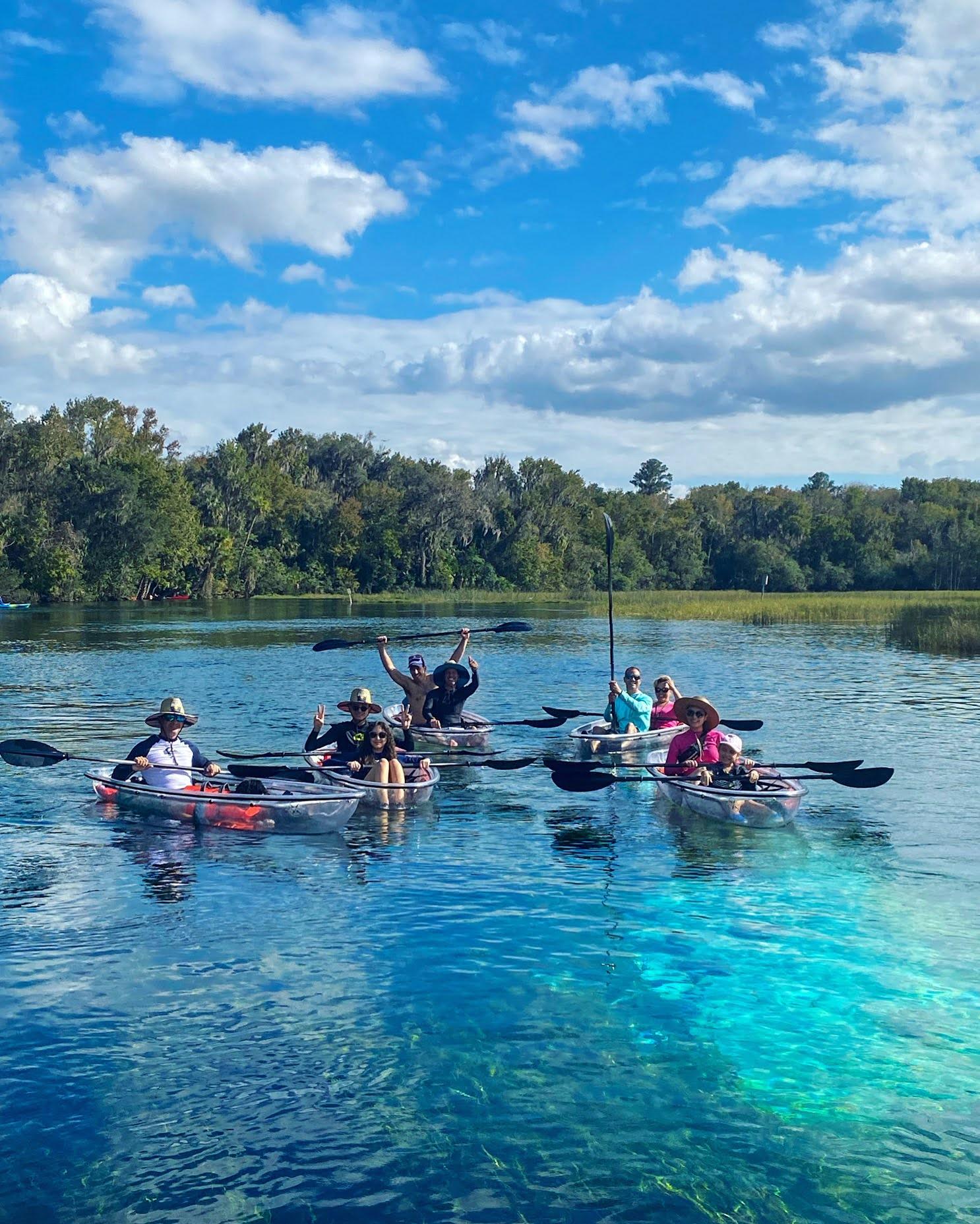 Group of kayakers enjoying a sunny day on a calm lake.
