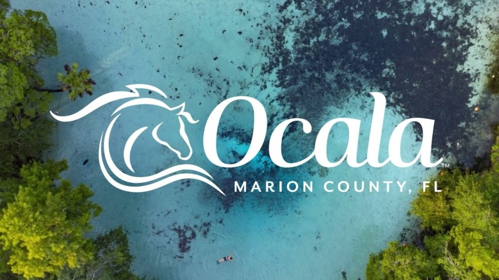 Aerial view of clear blue water and green foliage with 'Ocala Marion County, FL' text.