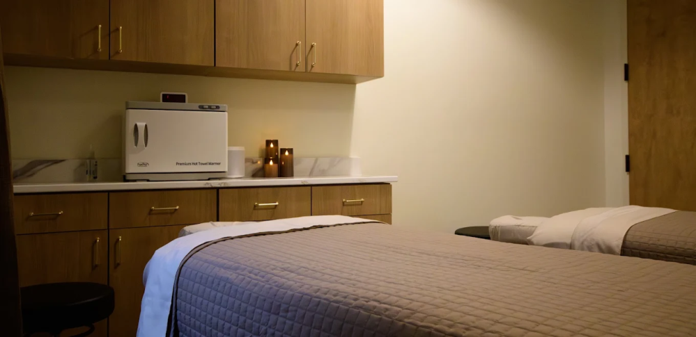 Spa room with massage tables and wooden cabinets.