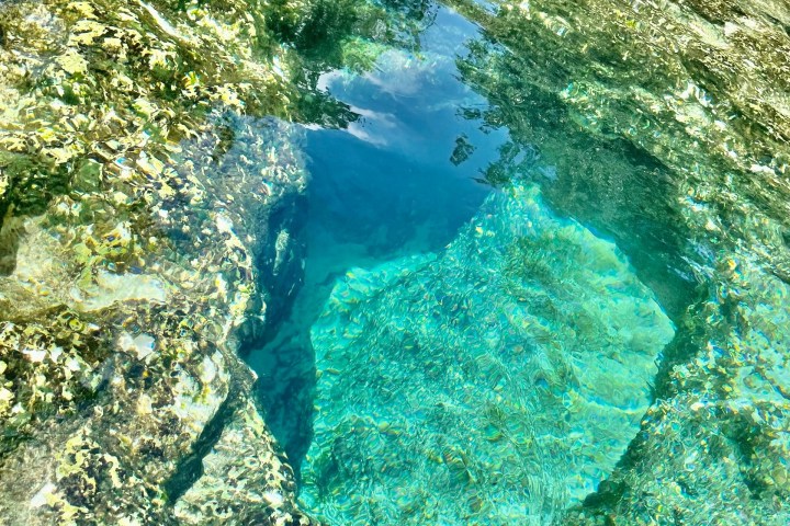 Clear water pool with underwater rocks and reflections.